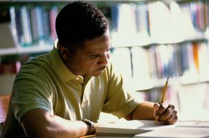 Image of man studying in library: Thinkstock